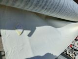 un rouleau de papier posé par terre à côté d'un rouleau de ruban adhésif