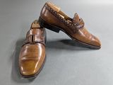 pair of men ' s brown leather shoes on a gray surface