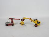 a toy truck and a toy crane on a white surface