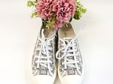 a bouquet of pink flowers sitting on top of a pair of sneakers