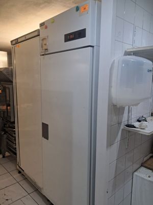 un réfrigérateur blanc dans une cuisine au sol carrelé de blanc