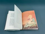 an open book with a picture of a woman sitting on a rock