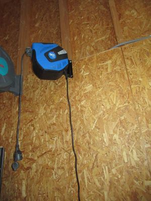 une photo d'un outil à cordon bleu et noir posé sur un parquet