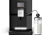 a black coffee machine sitting next to a glass of water