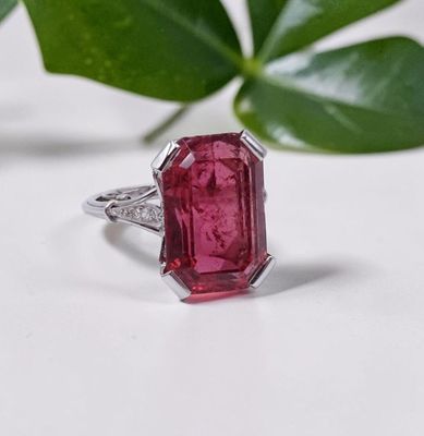 un gros plan d'une bague en tourmaline rose avec une feuille en arrière-plan