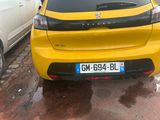 the yellow car is parked on the side of the road in the rain