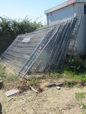 une clôture qui a été renversée devant un immeuble