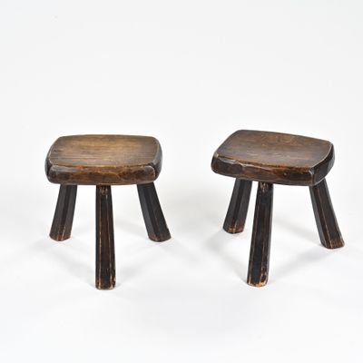 une paire de petits tabourets en bois aux pieds courbés, sur fond blanc