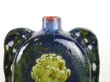 a blue and green vase with a picture of a woman on it