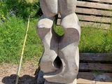 une sculpture en pierre représentant un couple assis sur un banc en bois