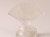 a clear glass vase that has a fan on top of it