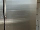 a large stainless steel refrigerator in a kitchen with a box on the floor