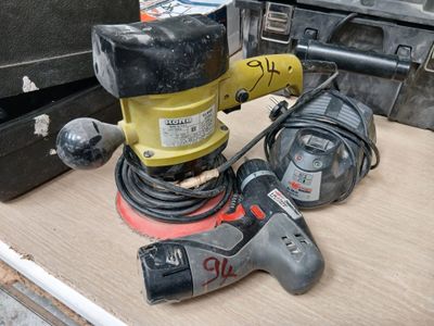 une photo d'une ponceuse et d'autres outils posés sur une table