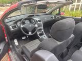 the interior of a red car with a steering wheel and dashboard