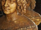 a bust of a woman sitting on a table next to a vase