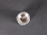 an overhead view of a silver plated object on a black surface
