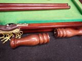 a pool table with a green cloth and a pair of wooden cues