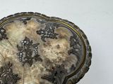 a silver heart shaped box with flowers and vines on it