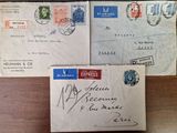 two envelopes with stamps are sitting on top of a wooden table