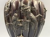 un vase orné d'un oiseau et un oiseau perché sur une branche