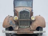 une vieille voiture toute rouillée, abandonnée par terre