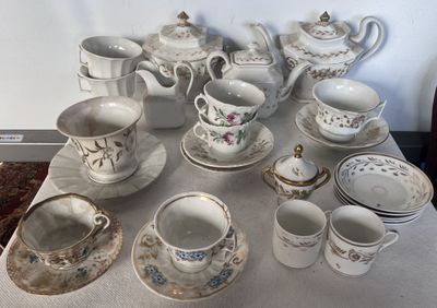 une table sur laquelle sont disposées de nombreuses tasses à thé et soucoupes