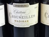 three bottles of red wine are lined up on a table