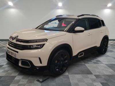 une Citroën blanche garée dans une pièce au sol carrelé