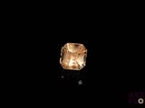 a close up of a yellow diamond on a black surface