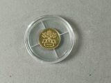 une pièce d'or dans un récipient en plastique transparent posé sur une table