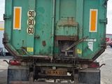 a green dump truck that is parked in a lot