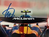 une image montrant un gros plan d'une voiture de course avec une signature sur le capot