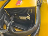 a close up of a yellow machine with a black hose