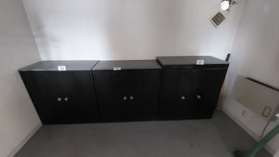 deux armoires noires dans un coin de la pièce
