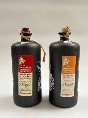 deux bouteilles d'alcool posées l'une à côté de l'autre sur une table