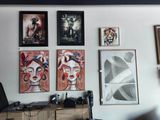 de nombreuses photos accrochées au mur au-dessus d'un bureau dans une pièce