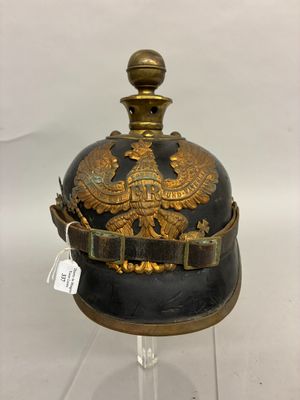 an old black and gold helmet with a gold eagle on it