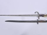 two old swords are laying side by side on a white surface