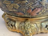 a gold vase sitting on top of a wooden table
