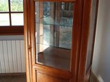 a wooden cabinet with a glass door in a room