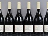 six bottles of wine are lined up in a row on a table
