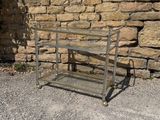 a metal cart that is sitting in front of a stone wall