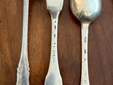three spoons and a fork on a table