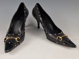 une paire d'escarpins en cuir noir avec des boucles dorées
