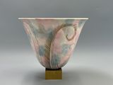 un vase rose et bleu orné d'une plume
