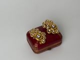 une petite boîte rouge ornée de quelques motifs dorés