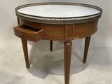 une table ronde avec un plateau en marbre et des pieds en bois