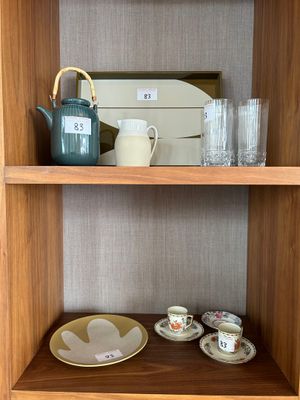 a wooden shelf with a tea pot and cups on it