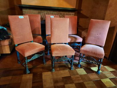 Plusieurs chaises sont alignées devant une cheminée dans un salon