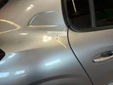 a silver car that has a sticker on the side of it